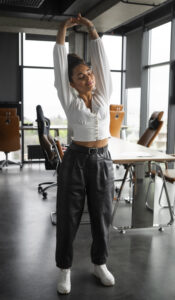 full shot woman stretching work